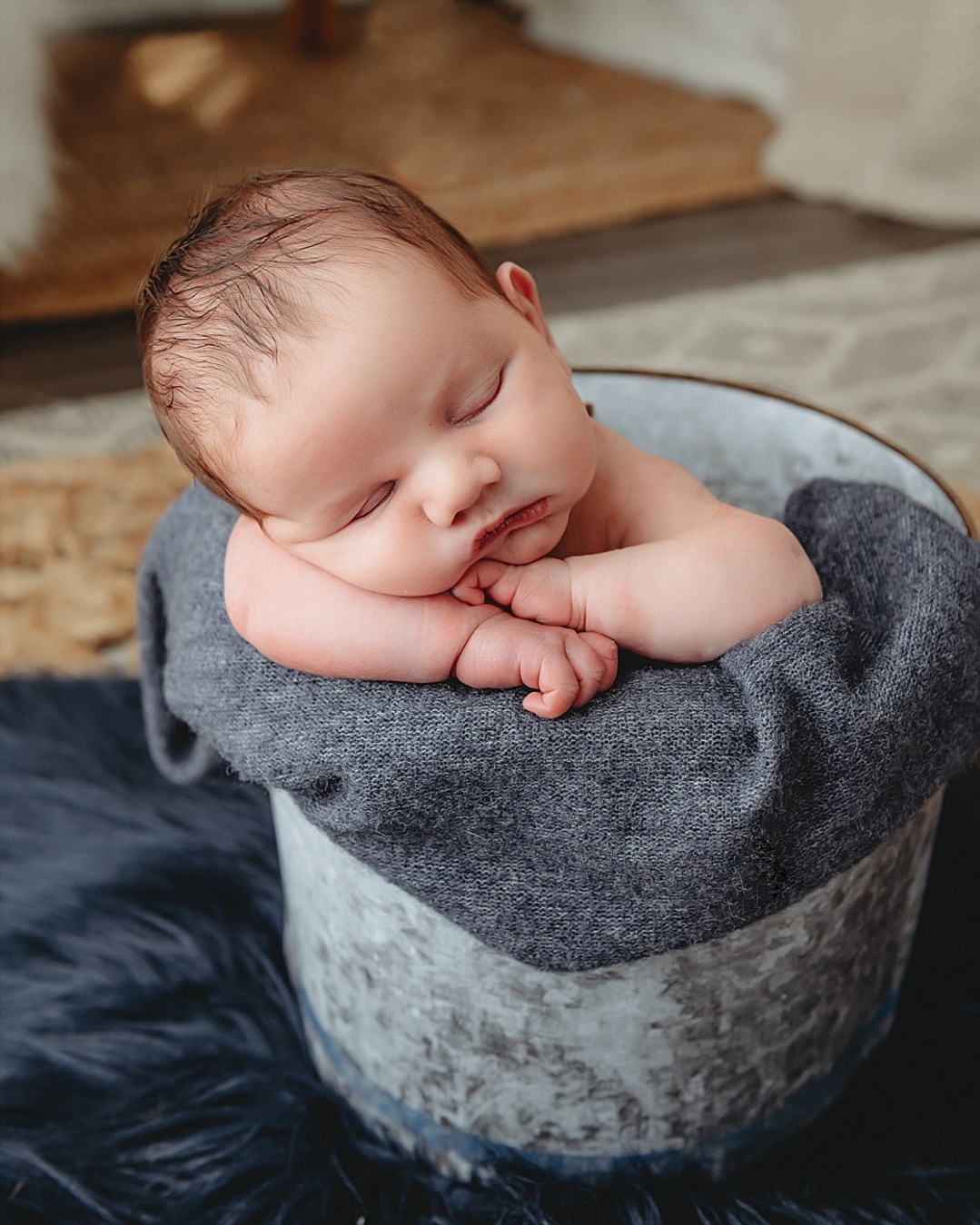 newborn baby in photography prop bucket for newborn photography session in Maryland
