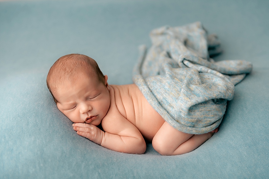Newborn baby boy in blue in Annapolis newborn photography session with blue blanket