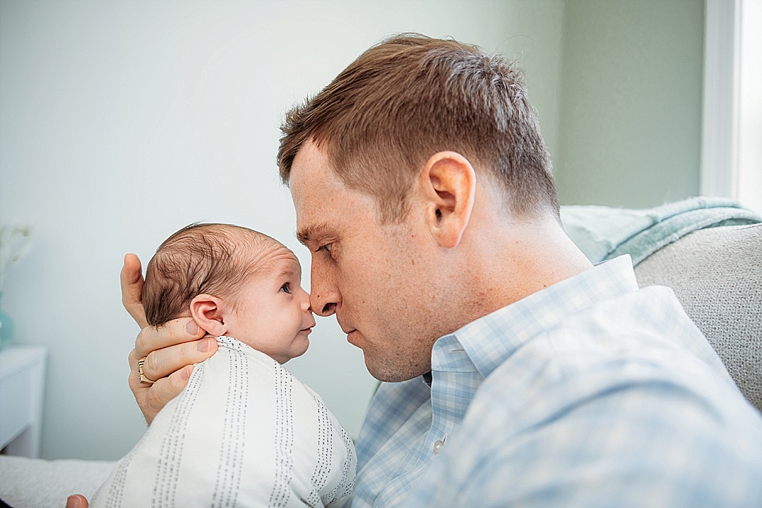 newborn baby in Annapolis photography lifestyle session with dad in blue and white shirt