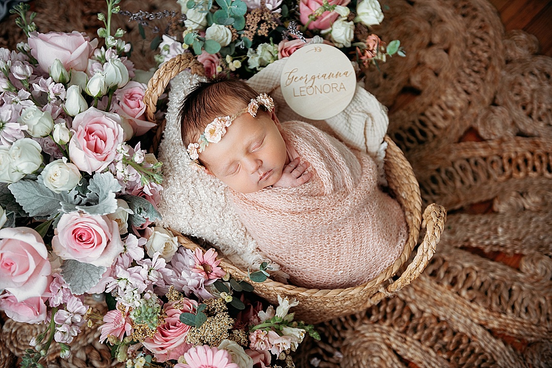 newborn baby girl with pink flowers and pink headband for Kent Island newborn photography session
