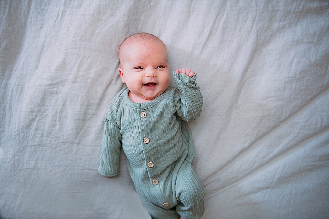 Baby boy in green jumper for Lifestyle newborn photography session in Annapolis