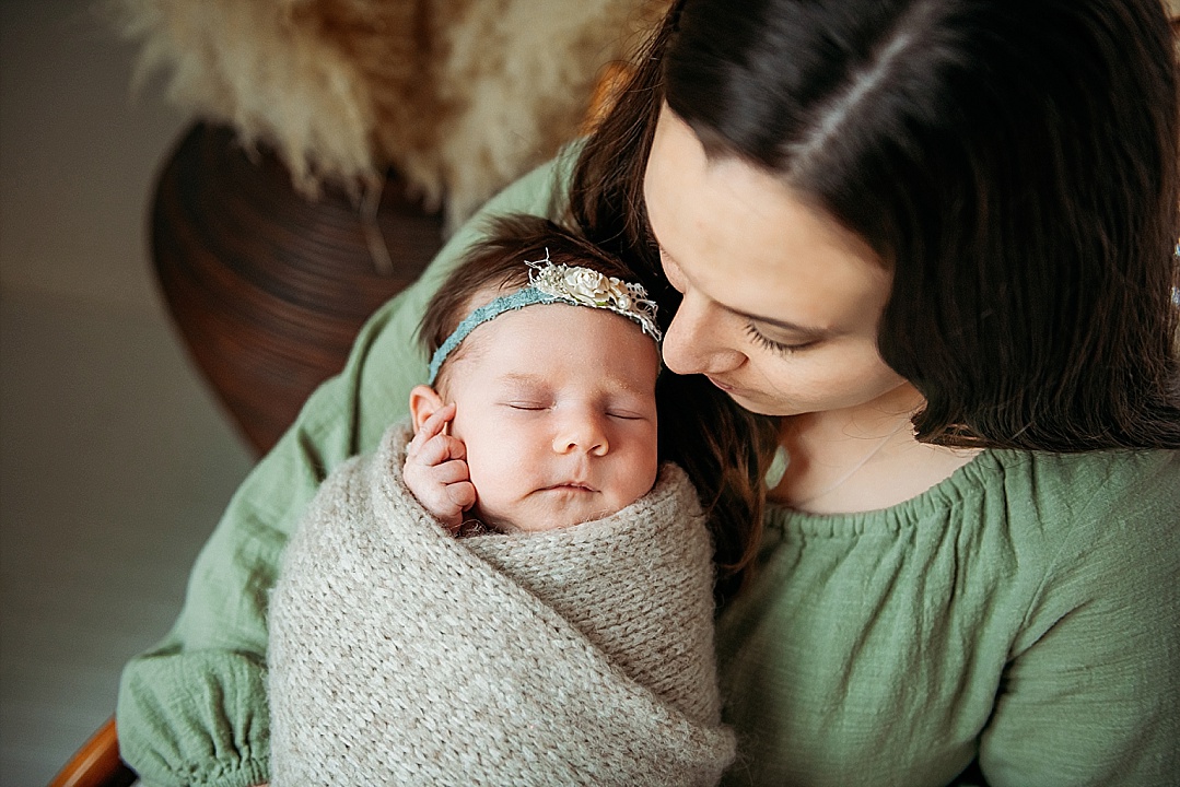 newborn wrapped baby girl with mama in green sweater for Maryland photography session