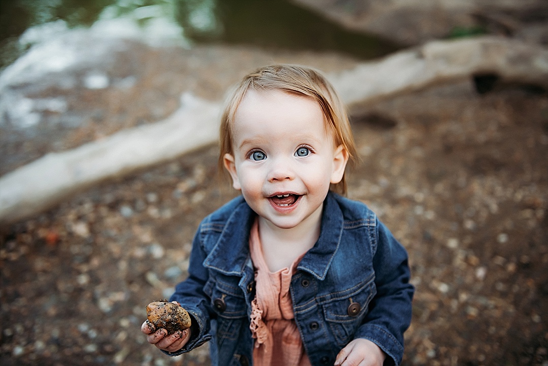 toddler girl in jean jacket playing by Maryland creek