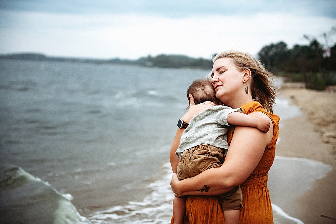 mom holding small child on beach
