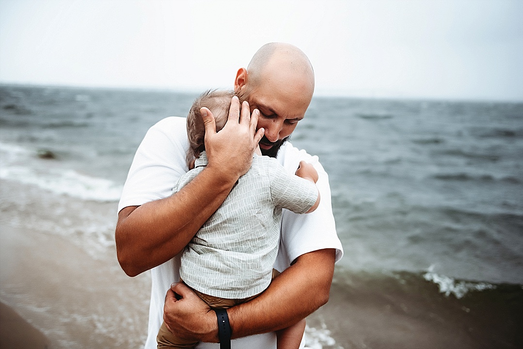 dad holding child on Annapolis beach in rain